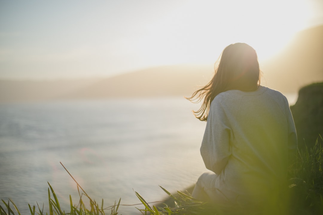 Adult facing a calm seascape, illustrating focused relaxation, guided attention, and hypnosis-related practice.